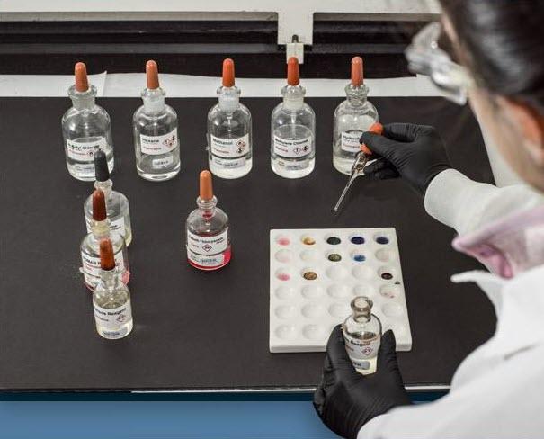 picture of 9 bottles and lab techch s